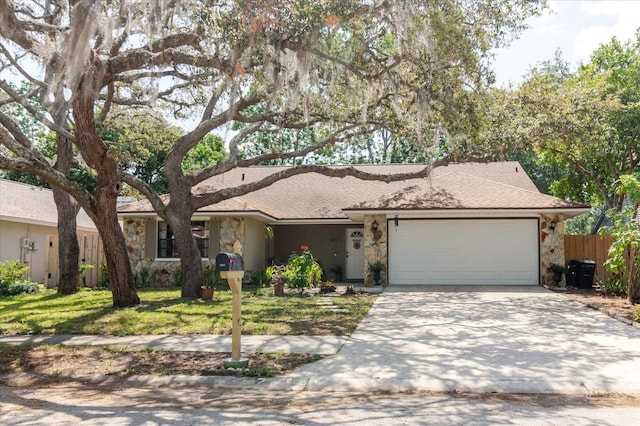 ranch-style house featuring fence, an attached garage, stone siding, a front yard, and driveway