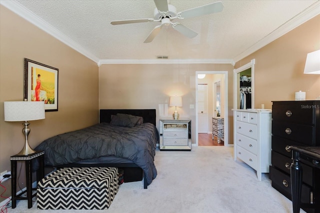 bedroom with ornamental molding, light carpet, a textured ceiling, and visible vents