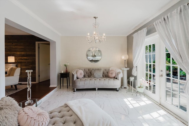 living room with an inviting chandelier, crown molding, wood walls, and marble finish floor
