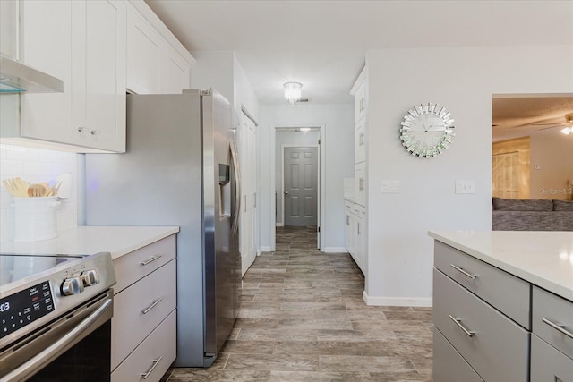 kitchen featuring light countertops, white cabinetry, light wood-style flooring, gray cabinetry, and stainless steel appliances