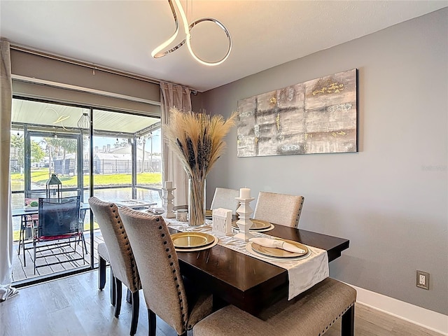 dining space featuring wood finished floors and baseboards