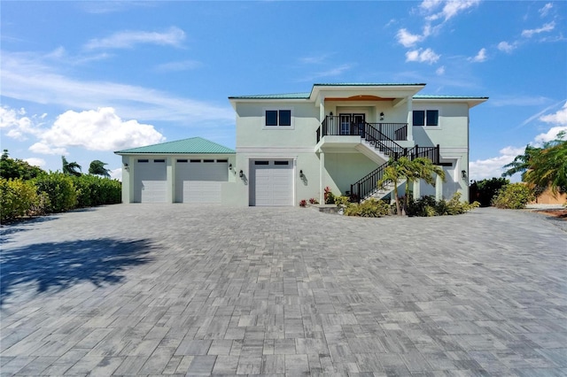 935 Chipaway Dr, Apollo Beach, FL 33572 - raised beach house featuring stairway, stucco siding, decorative driveway, and an attached garage