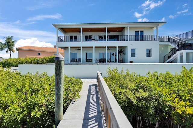 935 Chipaway Dr, Apollo Beach, FL 33572 - rear view of property featuring a ceiling fan, stucco siding, a balcony, and stairs