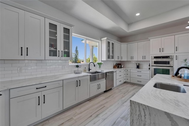 935 Chipaway Dr, Apollo Beach, FL 33572 - kitchen featuring a sink, appliances with stainless steel finishes, decorative backsplash, light stone counters, and recessed lighting