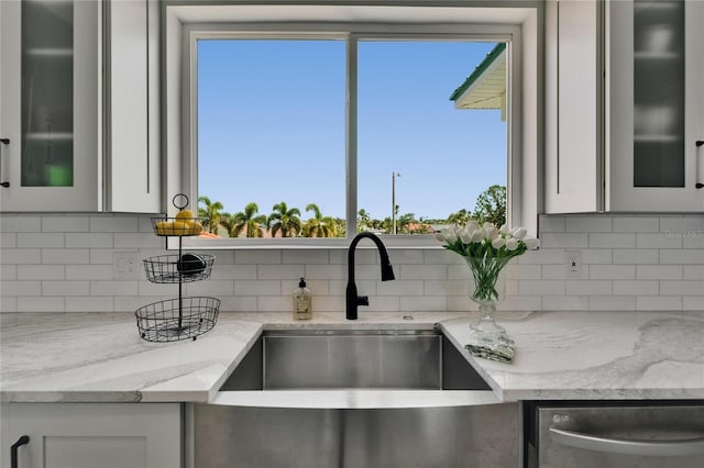 935 Chipaway Dr, Apollo Beach, FL 33572 - kitchen with a sink, stainless steel dishwasher, decorative backsplash, white cabinetry, and light stone countertops