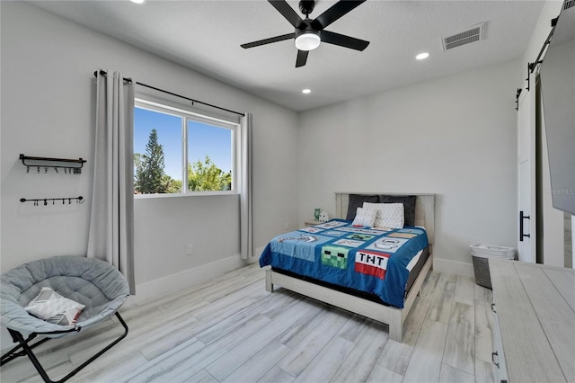 935 Chipaway Dr, Apollo Beach, FL 33572 - bedroom with a barn door, light wood finished floors, baseboards, recessed lighting, and ceiling fan