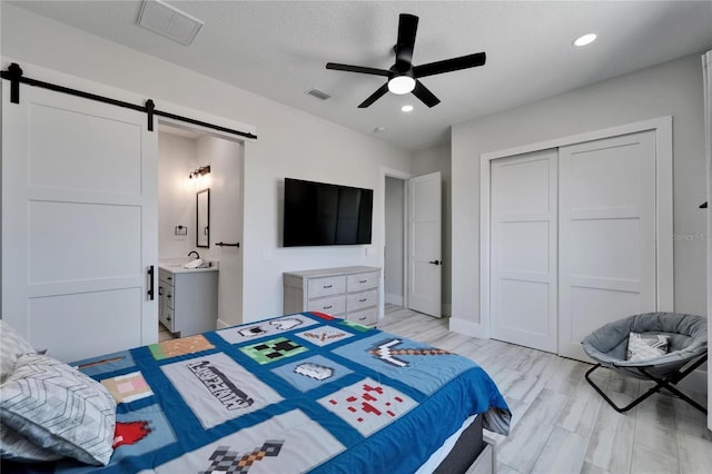 935 Chipaway Dr, Apollo Beach, FL 33572 - bedroom featuring a barn door, a closet, recessed lighting, ceiling fan, and baseboards