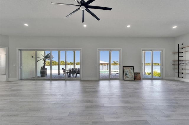 935 Chipaway Dr, Apollo Beach, FL 33572 - unfurnished living room with baseboards, light wood-type flooring, recessed lighting, a water view, and a ceiling fan