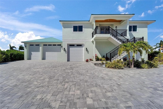 935 Chipaway Dr, Apollo Beach, FL 33572 - view of front facade featuring stairway, stucco siding, decorative driveway, and an attached garage