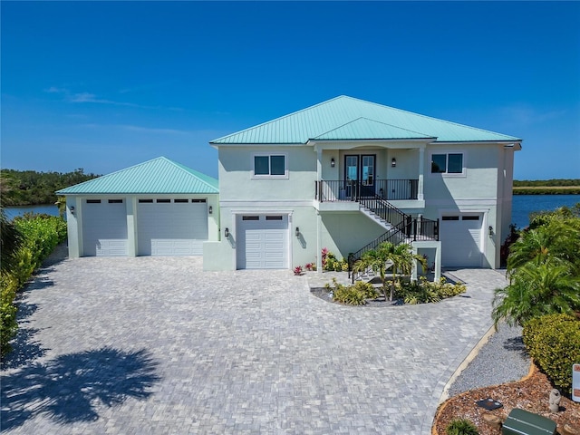 935 Chipaway Dr, Apollo Beach, FL 33572 - beach home with stucco siding, stairway, metal roof, and decorative driveway