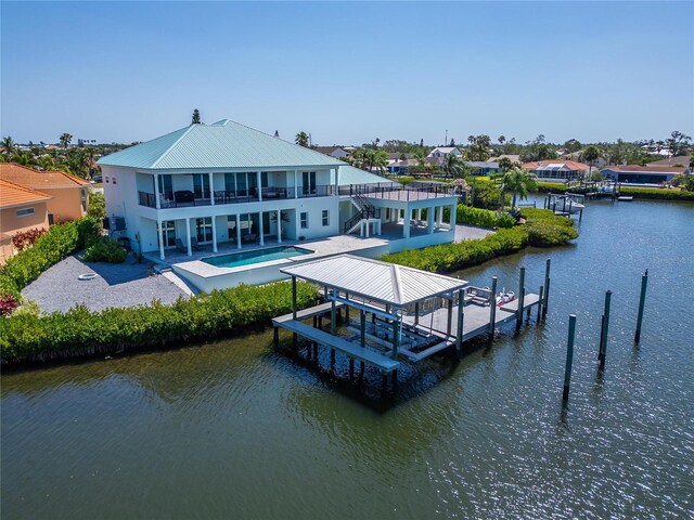 935 Chipaway Dr, Apollo Beach, FL 33572 - rear view of property with boat lift, a water view, a balcony, a patio, and metal roof