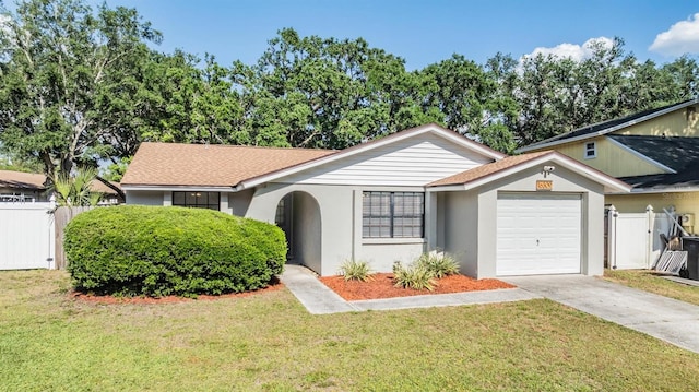 single story home with concrete driveway, an attached garage, fence, and a front yard