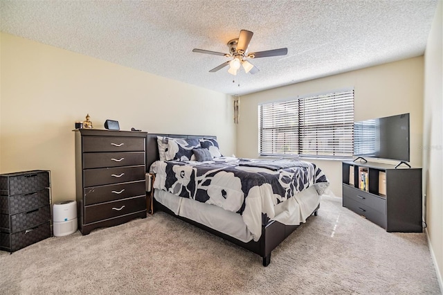 carpeted bedroom featuring a ceiling fan and a textured ceiling
