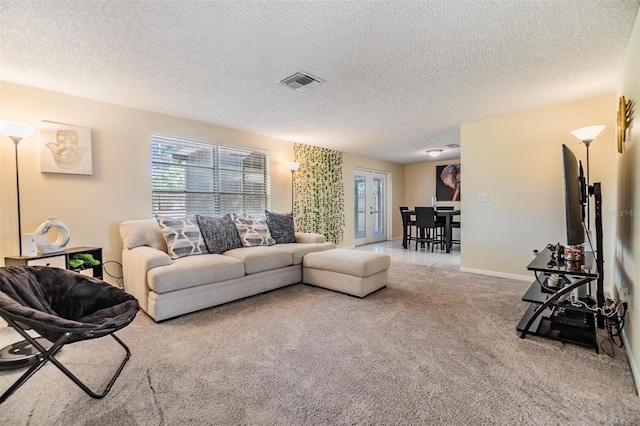 living room featuring visible vents, a textured ceiling, and carpet
