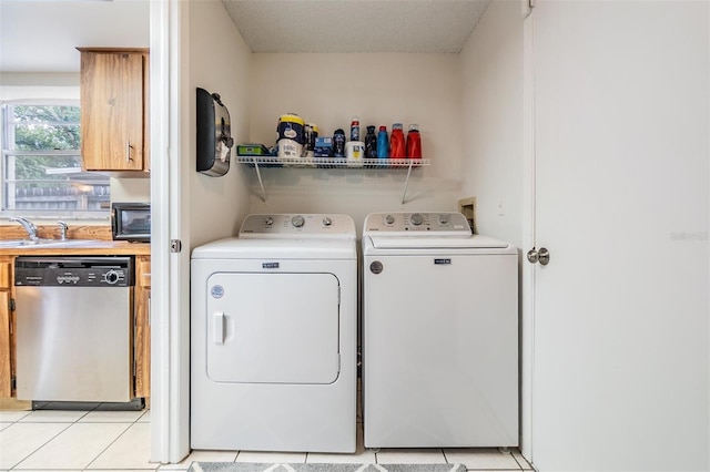 laundry room featuring a sink, light tile patterned floors, laundry area, and washing machine and clothes dryer