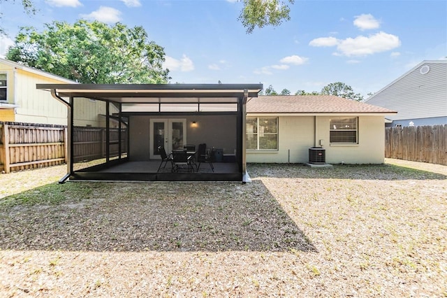 back of house featuring french doors, a patio area, central AC, a fenced backyard, and concrete block siding