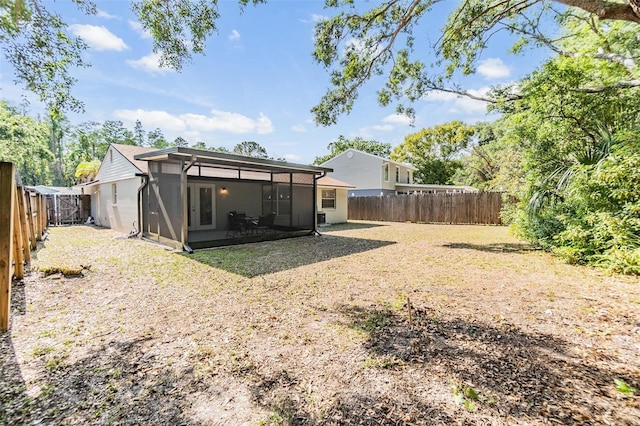 back of house featuring a sunroom and a fenced backyard
