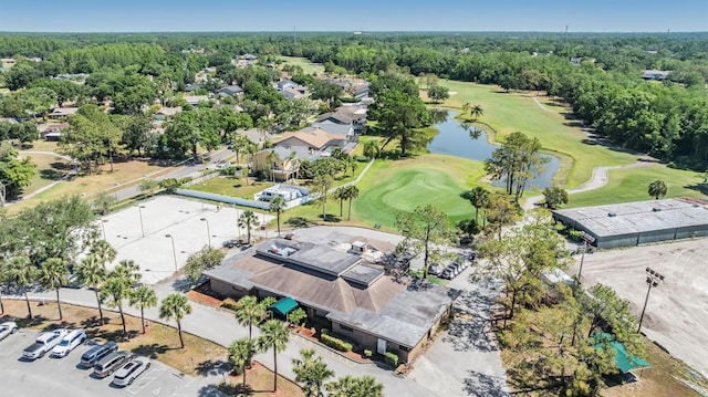 drone / aerial view with a residential view, view of golf course, and a water view