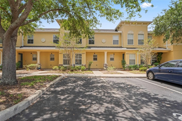 view of front of house featuring stucco siding and uncovered parking