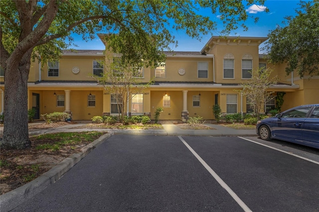 view of front facade with uncovered parking and stucco siding
