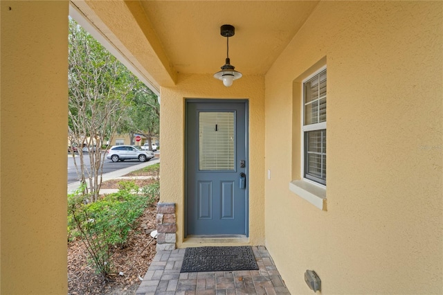 view of exterior entry with stucco siding