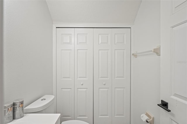 bathroom featuring toilet and a closet