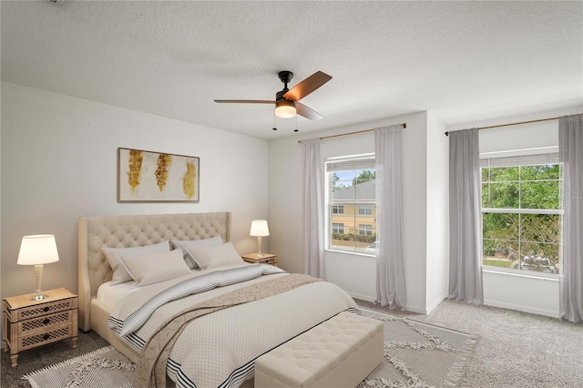 carpeted bedroom featuring baseboards, a ceiling fan, and a textured ceiling