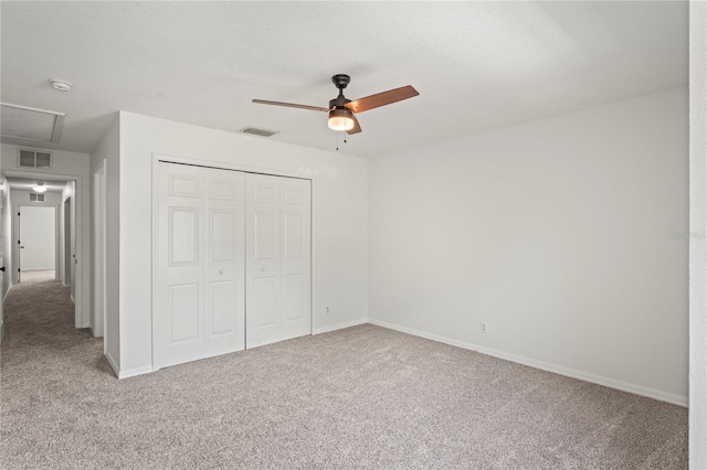 unfurnished bedroom with baseboards, visible vents, carpet, and a closet