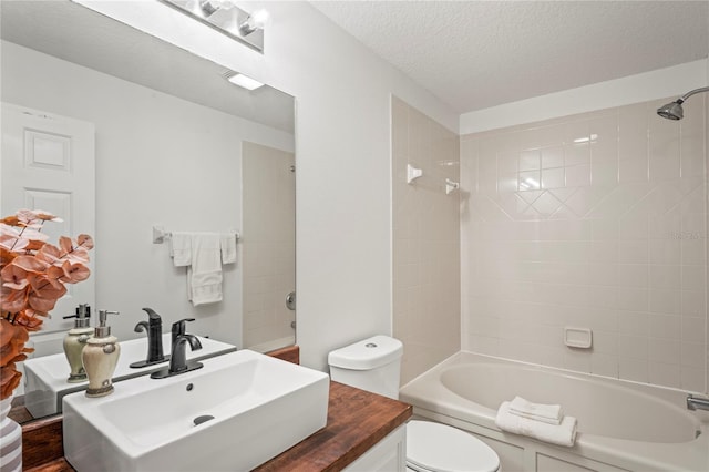 full bath with toilet, a textured ceiling, shower / tub combination, and vanity