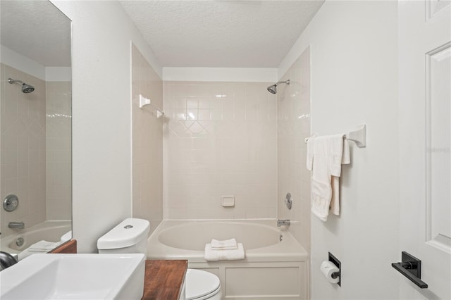 bathroom with a sink, a textured ceiling, bathtub / shower combination, and toilet