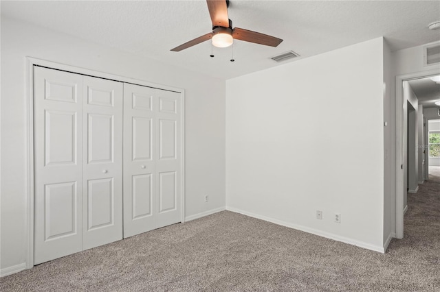 unfurnished bedroom with carpet floors, a ceiling fan, a closet, and visible vents