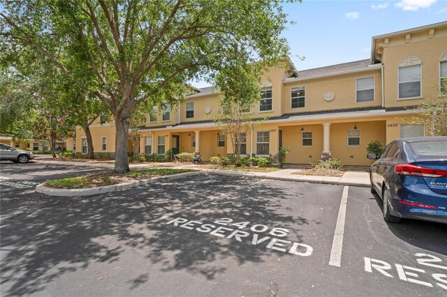 view of property with stucco siding and uncovered parking