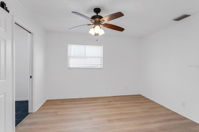 unfurnished bedroom featuring a closet, visible vents, ceiling fan, and light wood-type flooring