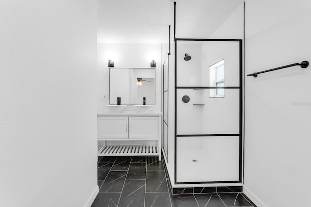 bathroom featuring marble finish floor, vanity, baseboards, a stall shower, and a ceiling fan