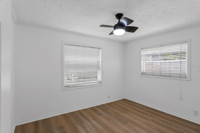 unfurnished room with a textured ceiling, dark wood-style flooring, and baseboards