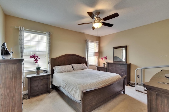bedroom featuring ceiling fan, light colored carpet, and baseboards