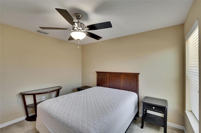bedroom with baseboards, ceiling fan, light carpet, and visible vents