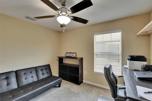 carpeted office space featuring baseboards, ceiling fan, and visible vents