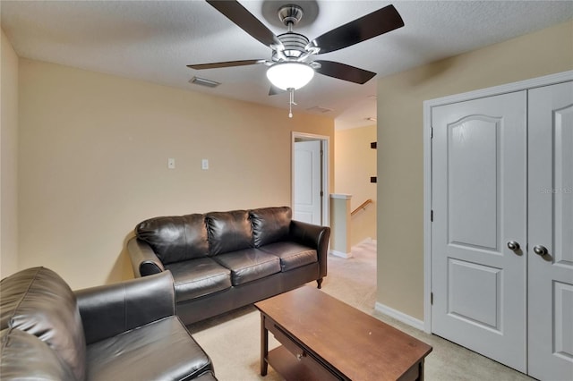 living room with baseboards, ceiling fan, light colored carpet, and visible vents