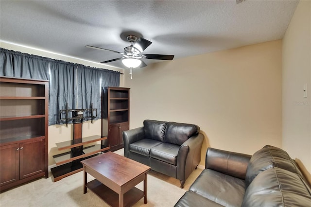 living room featuring ceiling fan, a textured ceiling, and light colored carpet