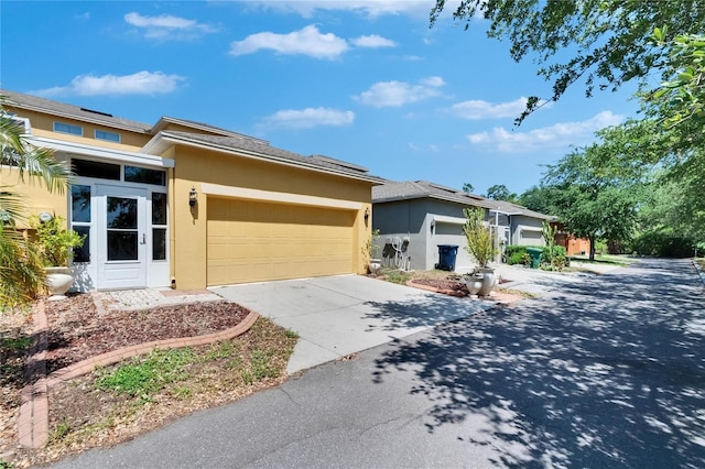view of front of home with concrete driveway, a garage, and stucco siding