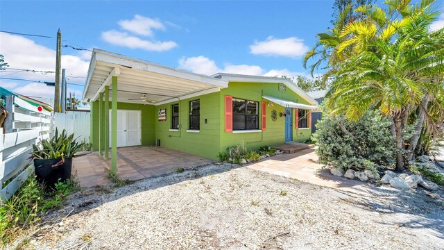 121 86th Ter, Treasure Island, FL 33706 - view of front facade with fence, a ceiling fan, and an attached carport