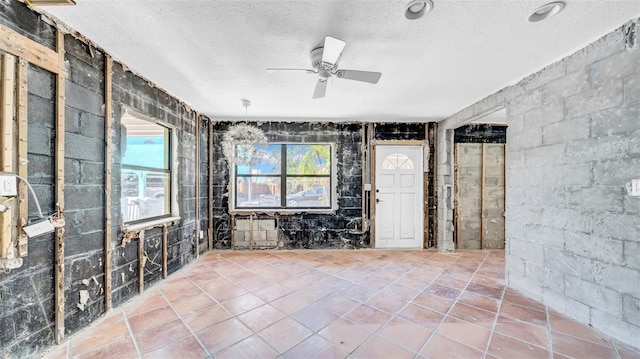 121 86th Ter, Treasure Island, FL 33706 - spare room with a textured ceiling, ceiling fan, and concrete block wall