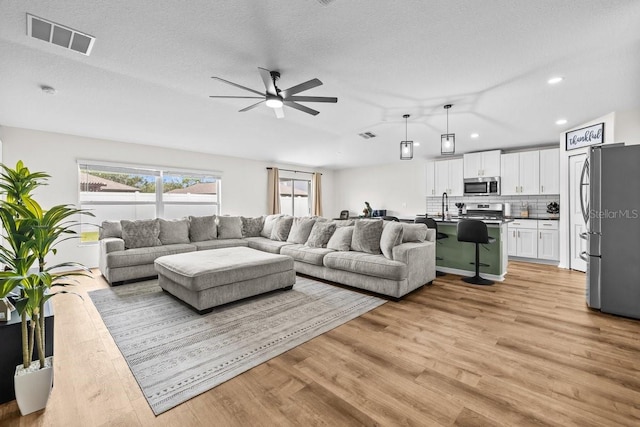 10333 Scarlet Skimmer Dr, Riverview, FL 33578 - living area featuring a ceiling fan, light wood-type flooring, recessed lighting, lofted ceiling, and a textured ceiling