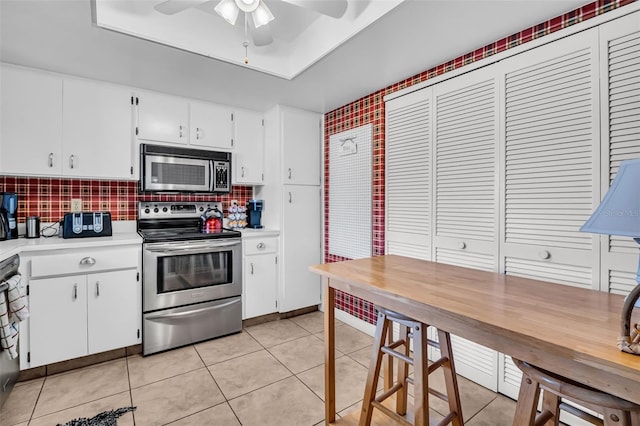 2506 Laurelwood Dr Unit 4C, Clearwater, FL 33763 - kitchen with white cabinets, light countertops, stainless steel appliances, a ceiling fan, and tasteful backsplash