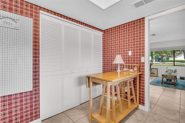 2506 Laurelwood Dr Unit 4C, Clearwater, FL 33763 - dining space with visible vents, light tile patterned flooring, and tile walls