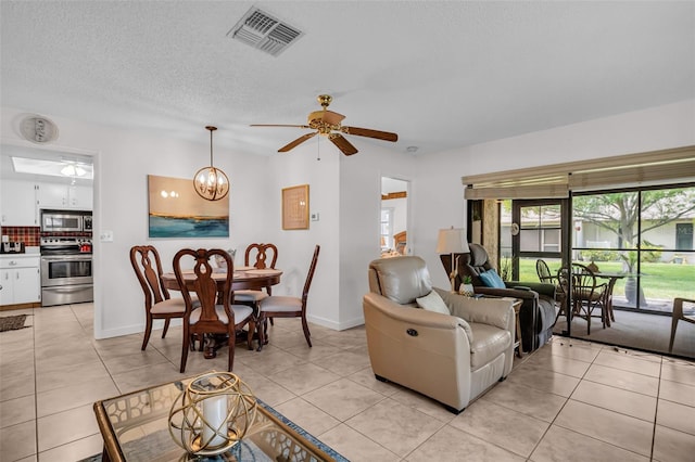 2506 Laurelwood Dr Unit 4C, Clearwater, FL 33763 - living area featuring visible vents, baseboards, ceiling fan with notable chandelier, and light tile patterned floors