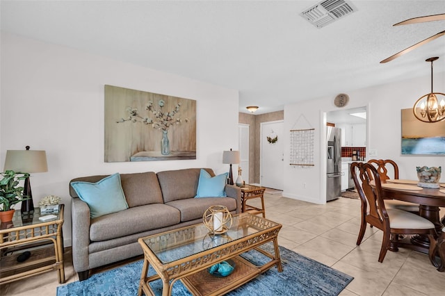 2506 Laurelwood Dr Unit 4C, Clearwater, FL 33763 - living room with visible vents, light tile patterned floors, and ceiling fan with notable chandelier