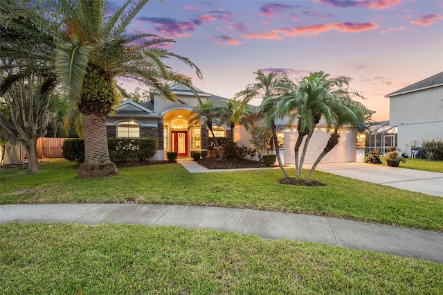 view of front of property featuring a front lawn, driveway, stucco siding, and fence