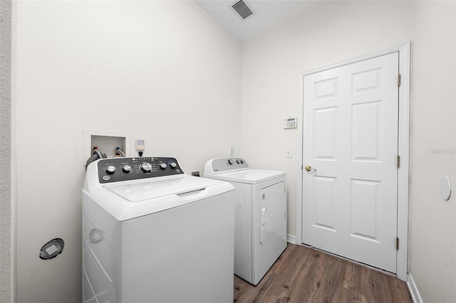 laundry room featuring washer and clothes dryer, visible vents, laundry area, and dark wood-style floors